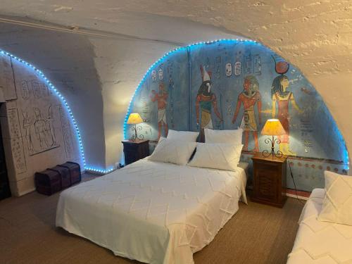 a room with two beds and a mural on the wall at Gites au Château des Estubiers in Les Granges-Gontardes