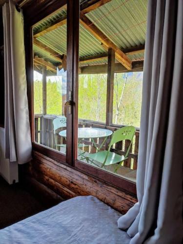 une pièce avec une fenêtre avec une table et des chaises dans l'établissement Petit mazot à la montagne pour 2 personnes, à Châtillon-sur-Cluses