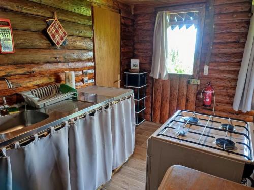 - une cuisine dans une cabane en rondins avec cuisinière dans l'établissement Petit mazot à la montagne pour 2 personnes, à Châtillon-sur-Cluses