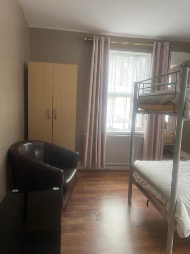 a bedroom with a bunk bed and a chair at Medway Stay in Chatham