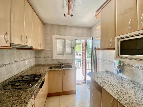 a kitchen with a counter and a sink and a microwave at AYRES APART in Calafell