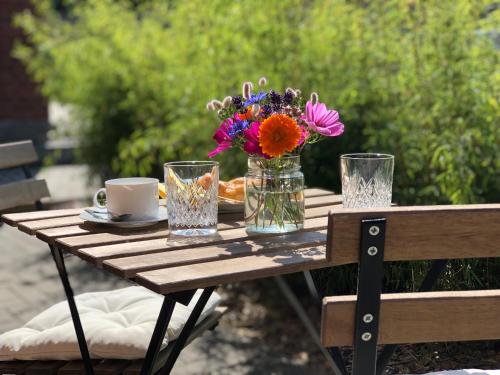 a wooden table with a vase of flowers on it at Ferienwohnung Elbsegler in Bleckede