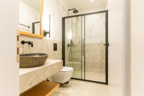 a bathroom with a sink and a toilet and a shower at Athesense Suites in Athens
