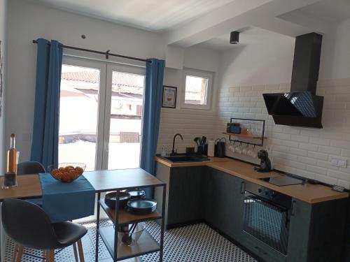 a kitchen with a counter and a table and a window at Holiday Apartment ORA in Balchik