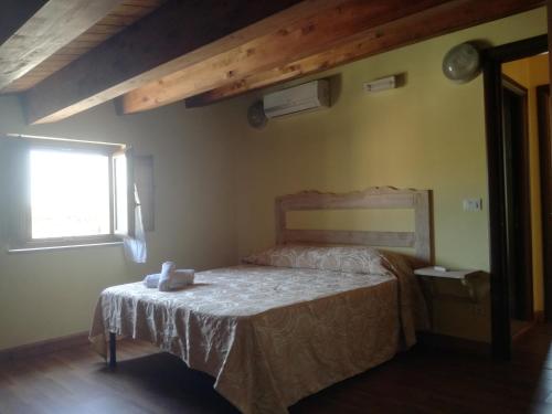 um quarto com uma cama num quarto com uma janela em Albergo Diffuso IL MIGLIO em Miglierina