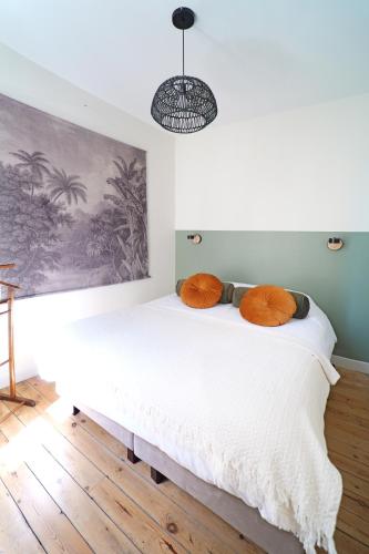 - une chambre dotée d'un lit avec des oreillers orange dans l'établissement Villa Adèle, vue mer, sauna et plage, à Mers-les-Bains
