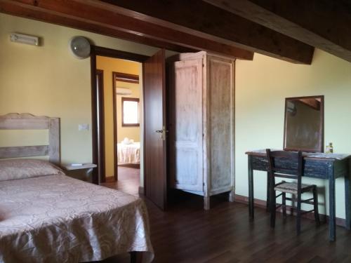 a bedroom with a bed and a desk and a table at Albergo Diffuso IL MIGLIO in Miglierina