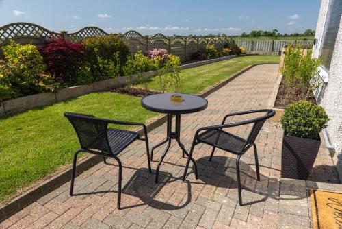 a table and two chairs on a brick patio at Causeway Coast Retreats in Dervock