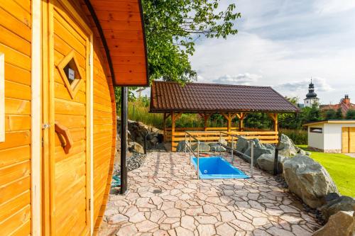 a backyard with a pool and a pavilion at Restaurace a penzion Pod Lipami Metylovice in Metylovice