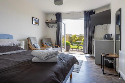 a bedroom with a bed and a view of a patio at Causeway Coast Retreats 