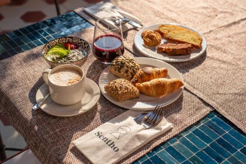 a table with plates of food and a cup of coffee at Sentho Roma in Rome