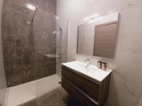 a bathroom with a sink and a shower and a mirror at Luxury Penthouse with private pool in Tas-Samra