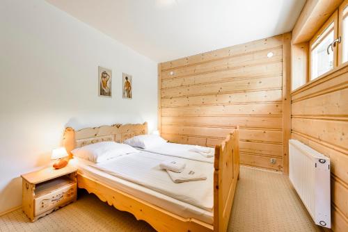 ザコパネにあるForster House - apartament nr 1 z kominkiem i tarasemの木製の壁の小さなベッドルーム