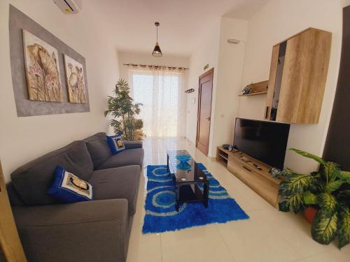 a living room with a couch and a tv at Luxury Penthouse with private pool in Tas-Samra