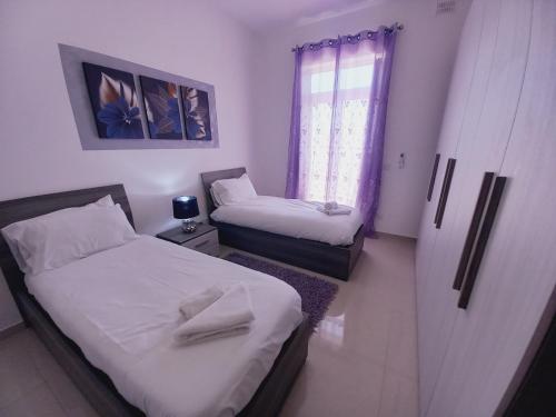 a small room with two beds and a window at Luxury Penthouse with private pool in Tas-Samra