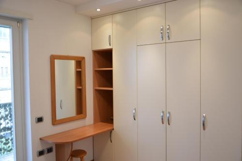 a dressing room with white cabinets and a mirror at Grand Hotel Liberty in Riva del Garda