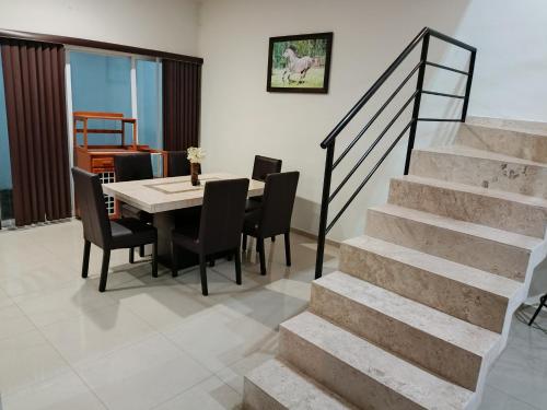 - une salle à manger avec une table, des chaises et des escaliers dans l'établissement Casa Real Santa Fé, à Villa de Alvarez