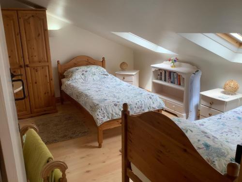 a small bedroom with two beds and a dresser at Hollyhock Cottage, Clematis cottages, Stamford in Stamford
