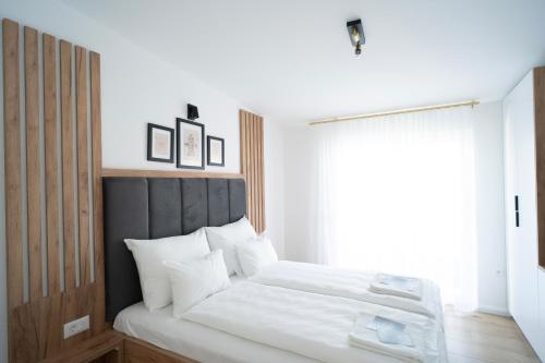 Schlafzimmer mit einem Bett mit weißer Bettwäsche und einem Fenster in der Unterkunft Villa Ritual in Mostar