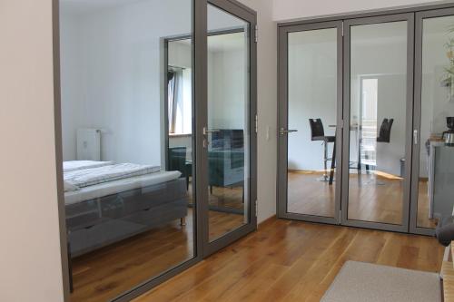 1 dormitorio con puertas correderas de cristal y 1 cama en Ferienwohnung Haus Knäppen Size S, en Oelde