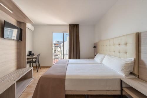 a bedroom with a large bed and a balcony at Hotel Queens - Adults Only in Benidorm