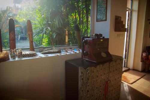 an old radio sitting on a stand in front of a window at Le Pavillon de l'Emyrne in Antananarivo