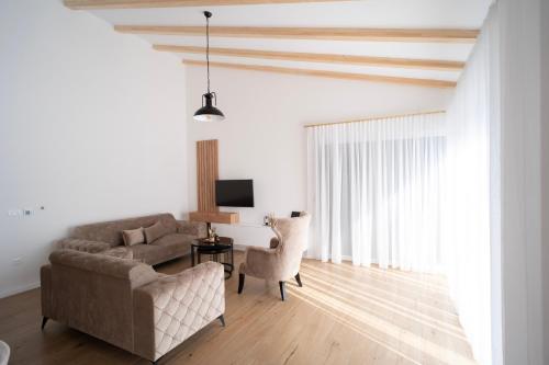 sala de estar con sofá, mesa y TV en Villa Ritual, en Mostar