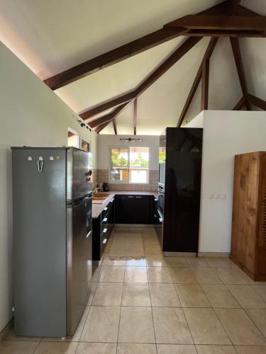 a kitchen with a stainless steel refrigerator in a room at O'coco Bungalow in Paea