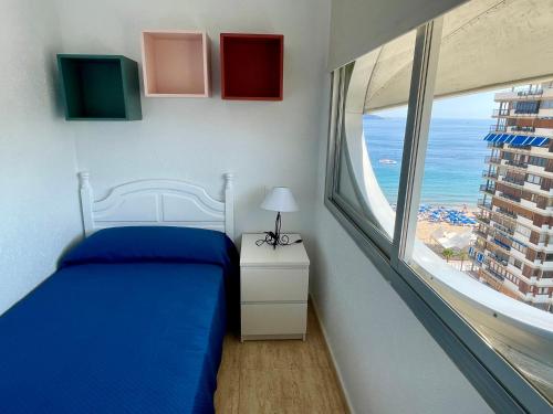 sypialnia z łóżkiem i dużym oknem w obiekcie Apartamento turístico Playmon Bacana Planta 13 w mieście Benidorm