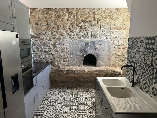 una cucina con lavandino e parete in pietra di Gîtes dans Domaine des Barrettes ad Agde