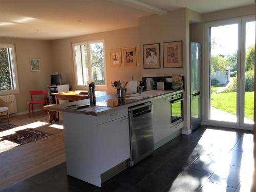 une cuisine avec un évier et une cuisinière four supérieur dans l'établissement La Maison du Fort de Fontain Villa Mac Mahon vue superbe Montagnes du Jura, à Fontain