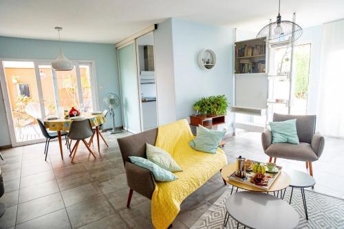 un salon avec un canapé jaune et une table dans l'établissement Location de vacances Le Pagnol, à Albi
