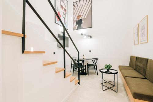 a living room with a staircase and a table at Athesense Suites in Athens