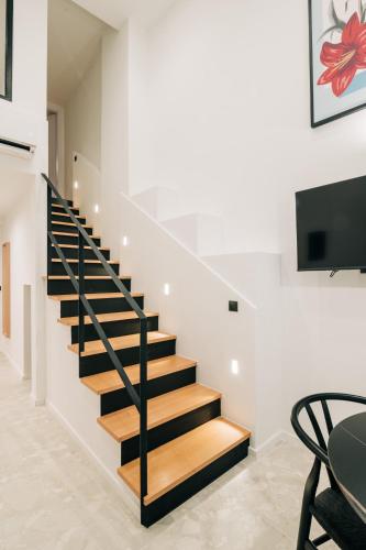 a staircase in a house with a table and a tv at Athesense Suites in Athens