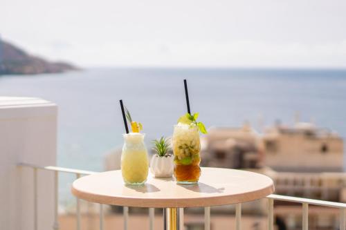 two cocktails sitting on a table on a balcony at Hotel Queens - Adults Only in Benidorm