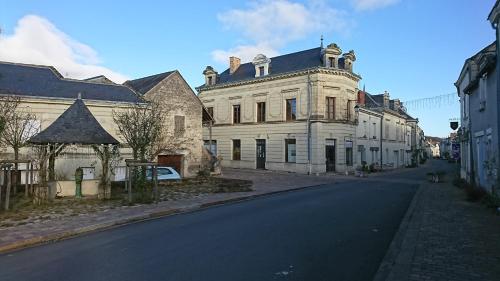 un gran edificio blanco al lado de una calle en La Marginale, en Fontevraud-l'Abbaye