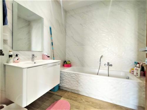 a white bathroom with a tub and a sink at MN Group Belgium Les Jardins de Carthage book via Airrbnb in Tunis