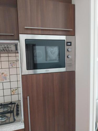 a microwave on a wooden cabinet in a kitchen at BPW 1105 - Bospark t Wolfsven in Mierlo