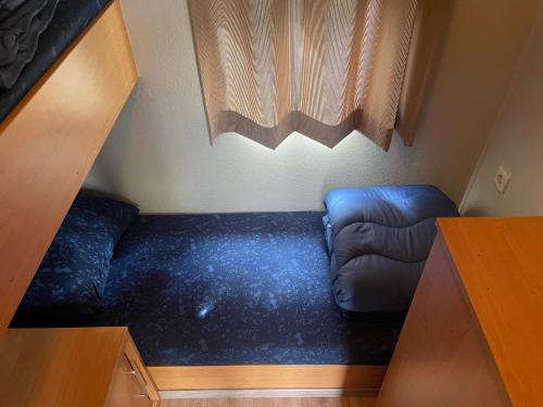 a blue couch in a small room with a window at BPW 1105 - Bospark t Wolfsven in Mierlo
