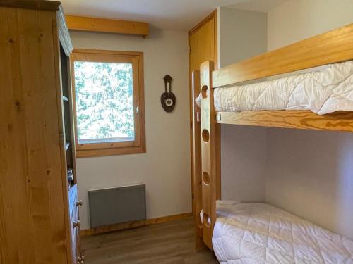 une chambre avec deux lits superposés et une fenêtre dans l'établissement Appartement 3 pièces à Méribel Altiport - Pied des pistes, proche golf, pour 6 personnes - FR-1-411-706, à Les Allues