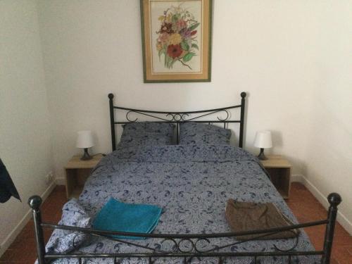 1 dormitorio con 1 cama con edredón azul y 2 lámparas en Mireval, en Mireval