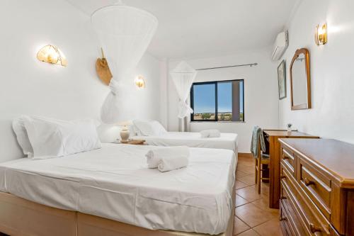 a white room with two beds and a kitchen at Pine Trees Penthouse in Olhos de Água