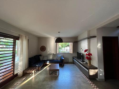 a living room with a blue couch and a tv at Bangalôs da Barra Chalé 3 in Barra Grande