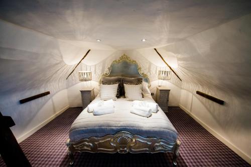 een slaapkamer met een groot bed met twee kussens bij Great Blunts House - Stock Brook Manor Golf Club in Stock