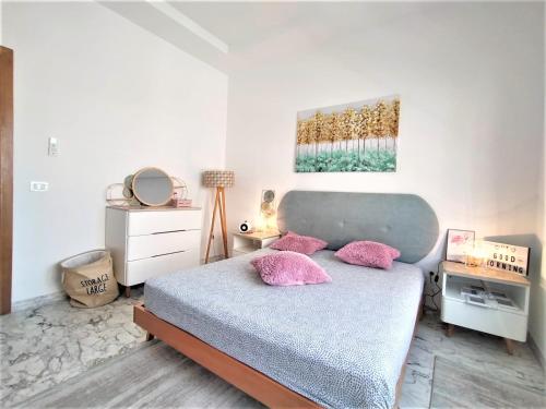um quarto com uma cama com almofadas cor-de-rosa em MN Group Belgium Les Jardins de Carthage book via Airrbnb em Tunes