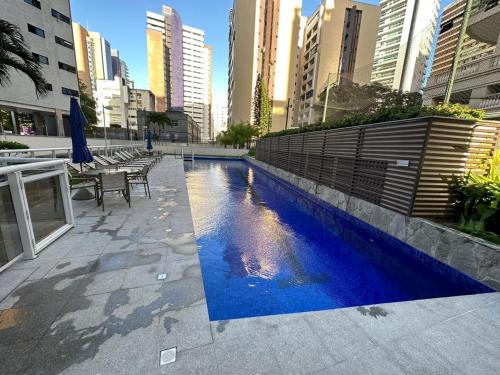 a swimming pool in a city with tall buildings at Helbor My Way - Compactos de luxo in Fortaleza