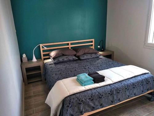 Ce lit se trouve dans une chambre dotée d'un mur vert. dans l'établissement M comme Maison à la mer, à La Londe-les-Maures