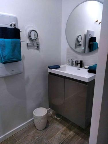 une salle de bain avec un lavabo et un miroir dans l'établissement M comme Maison à la mer, à La Londe-les-Maures