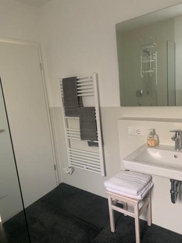 a bathroom with a sink and a stool next to a mirror at Studio mit Alpenblick in Kleinweil