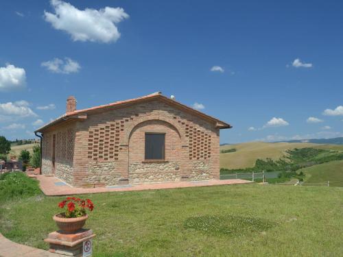 a small brick building in a field of grass at Cosy agriturismo in Toscana with outdoor swimming pool in Peccioli